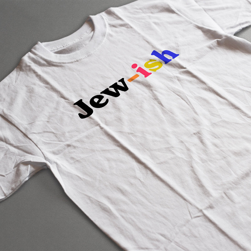 creased white t-shirt laying on a table  with a multicolored design that reads "jew-ish"