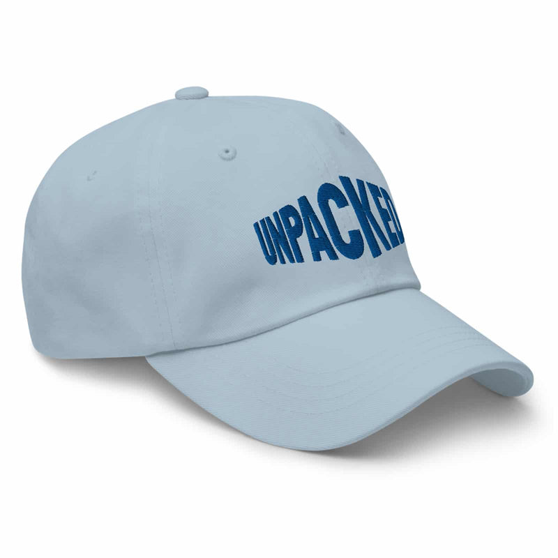 light blue dad hat with the Unpacked brand logo sewn in blue thread  Edit alt text