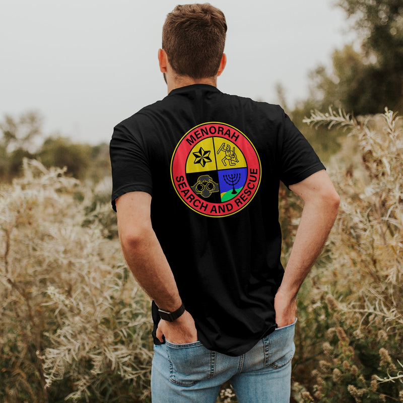 male model in field wearing the black "menorah search and rescue" shirt