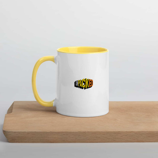 back of the MOT yellow and white ceramic mug, with the Unpacked brand logo displayed in a matching grungy design