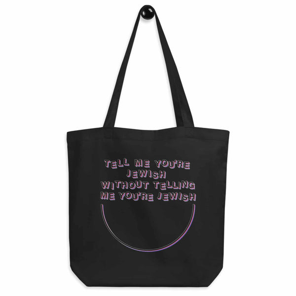 black tote bag with design that reads "tell me you're jewish without telling me you're jewish"